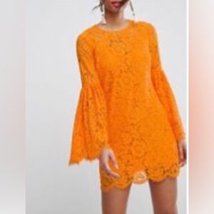 Lace trumpet sleeve mini dress. Low open back with one button closure